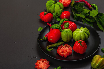 Green and red ribbed tomatoes, American or Florentine variety. Ripe vegetables, fresh bay leaves