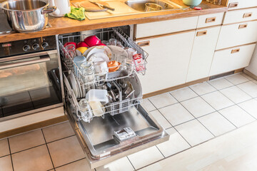 Nahaufnahme einer voll eingeräumten vollen bestückten Spülmaschine in einer Küche mit Geschirr...