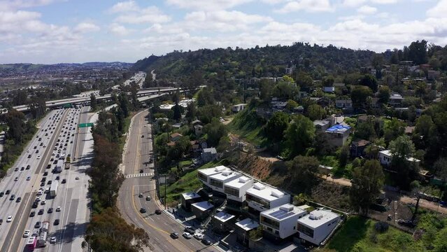 Aerial wide reverse pullback shot of the 5 Freeway with Downtown Los Angeles, California in the distance. 4K