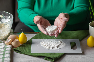 Old woman prepare cottage cheese pancakes on cutting board. Grandma hands in flour kneading dough,...