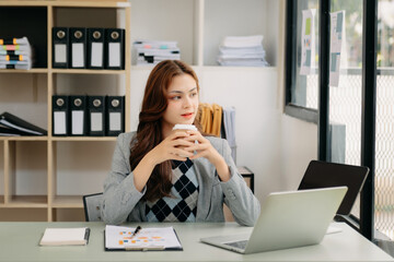 Asian businesswoman working in the office with working notepad, tablet and laptop documents .