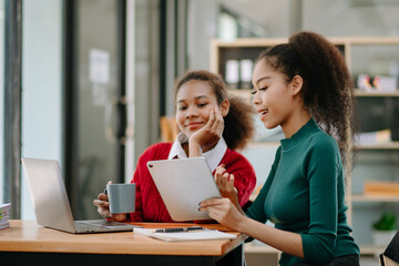 Business African woman leading team meeting and using tablet and laptop computer with financial in office