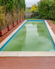 Following shock chlorination, the water in a swimming pool is white and cloudy