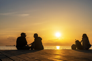 Menschen bei Sonnenuntergang am Meer