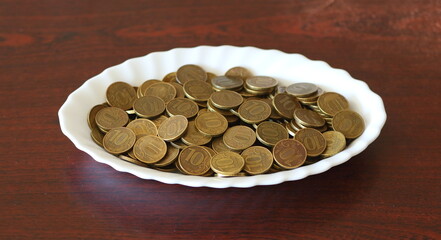 Yellow ten-ruble coins on a white oval dish