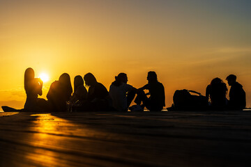 Menschen bei Sonnenuntergang am Meer