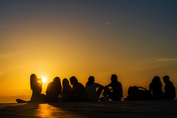 Menschen bei Sonnenuntergang am Meer
