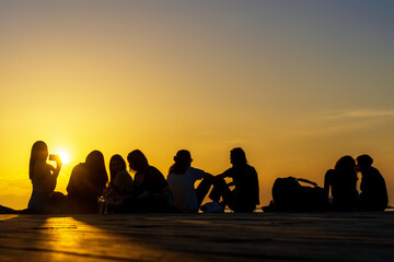 Menschen bei Sonnenuntergang am Meer