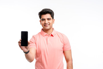 Young man standing in casual t shirt and showing smartphone screen.