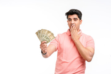 Indian man holding five hundred bank note in hand and giving unbelievable expression.