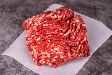 Minced meat on butcher paper. Fresh ground beef on wood background. Close up