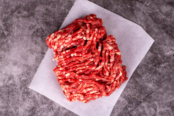 Minced meat on butcher paper. Fresh ground beef on wood background. Top view