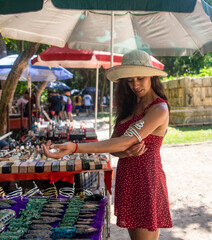 Photo of tourist buying a bracelet at a street stall selling costume jewelry and gifts at the...