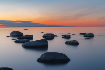 Fototapeta na wymiar Sunset long exposure on the Baltic sea coast with boulders