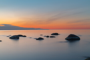 Fototapeta na wymiar Sunset long exposure on the Baltic sea coast with boulders