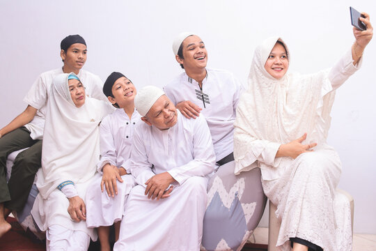 Potrait of family muslim take a picture or wefie using smartphone during eid mubarak moment 