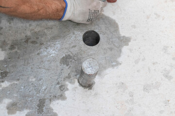 Drilling machine hole and cylinder in concrete on the floor
