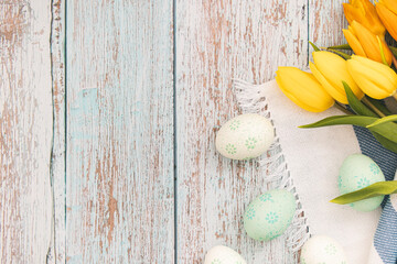 Easter decoration, flat lay, Easter eggs with yellow tulips on wooden table