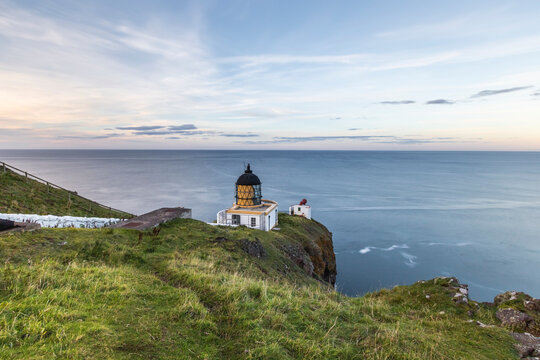 View of St Abb's Lighthouse along the coastline with cliffs, St Abb's Head, Eyemouth, United Kingdom.