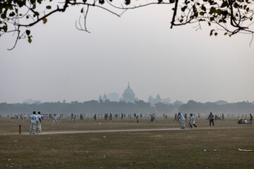 Maidan, Kolkata, India - 18 December 2022: view of people playing cricket in the largest playgroud of Maidan.