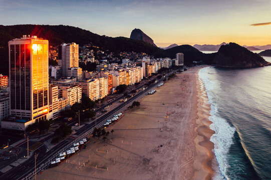 Aerial drone view of Leme Beach in the Copacabana district at sunrise with the iconic Sugarloaf Mountain in the background, UNESCO World Heritage Site, Rio de Janeiro, Brazil