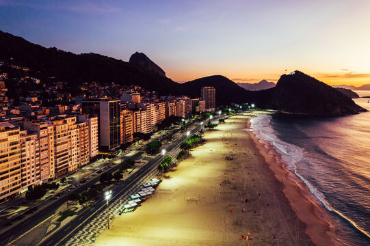 Aerial drone view of Leme Beach in the Copacabana district at sunrise with the iconic Sugarloaf Mountain in the background, UNESCO World Heritage Site, Rio de Janeiro, Brazil