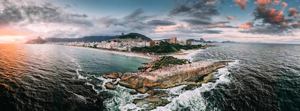 Aerial drone panorama of Ipanema and Copacabana beaches at sunset with Arpoador Rock closest to foreground and Sugarloaf Mountain visible, Rio de Janeiro, Brazil