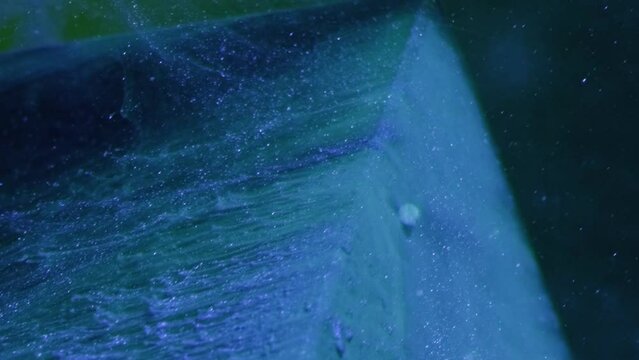Vertical video. Glitter splash. Ink water. Snow cascade. Blue color paint smoke flow motion over ice cube angle on dark abstract background.