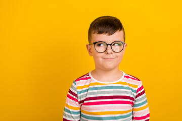Photo of positive boy wear striped stylish clothes interested look empty space school supplies isolated on yellow color background