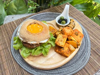 Egg bagel burger with falafel, tofu masala and chic pea with olive