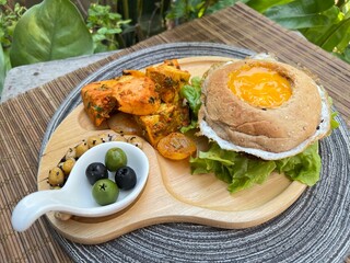 Egg bagel burger with falafel, tofu masala and chic pea with olive