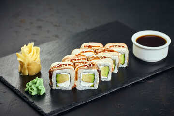 Sushi roll with eel, avocado, cream cheese on dark background. Sushi menu. Japanese food.