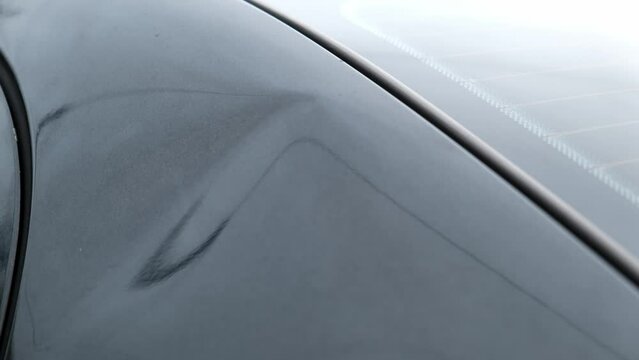 small dent on black car. Minor dent that does not require repainting.