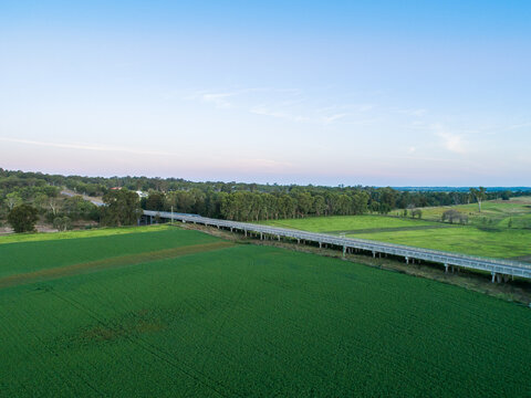 Bridge over floodplain growing crop of lucerne alfalfa feed