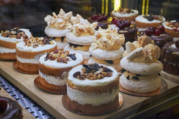 Bento cakes and other desserts with various flavors and decorations in display case for sale in the market. Fashion sweetness.