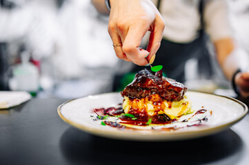 Chef decorated Stewed veal cheeks with mashed potatoes on restaurant kitchen