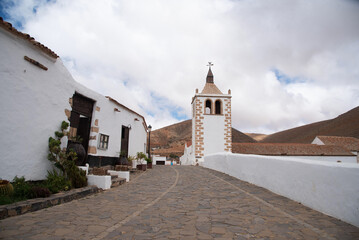 Vista panorámica de las antiguas calles del pueblo de Betancuria en Fuerteventura, con suelo de piedra y edificios blancos en un día nublado en las Islas Canarias.