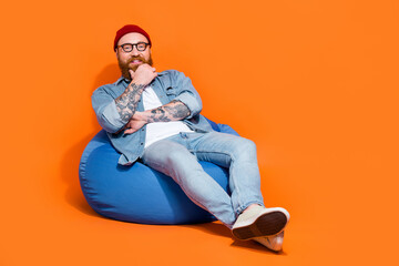 Photo of positive smart brutal manager guy sitting bean chair listen to new work applicant isolated on vivid color background