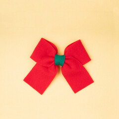 The Red gift bow on yellow color background.