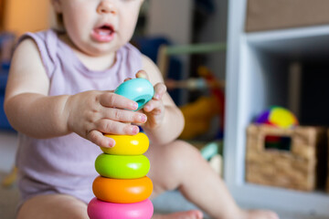 Baby learning through play developing fine motor skills with colourful stacking toy