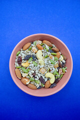 Fototapeta na wymiar A bowl with mixed seeds, nuts and fruits