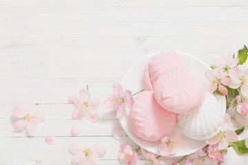 pink and white marshmallow with apple flowers on wooden background