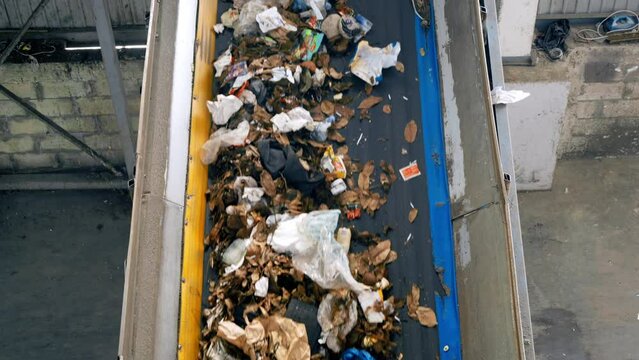 Garbage moving on a conveyor belt at waste sorting plant