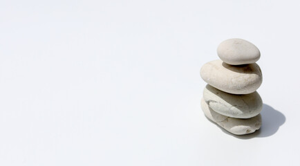Stacked peeble stones on isolated white background - zen and spa