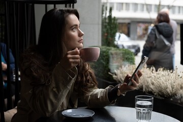 Young beautiful woman in the cafe with a cup of coffee working online or enjoying free time