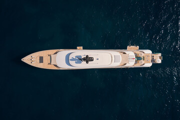 Innovative white big yacht anchored in the morning sun top view. Mega yacht on a dark background...