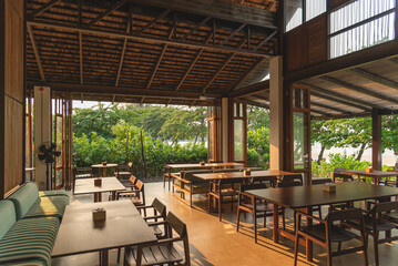 Wooden long table in dining areas in evening among sunlight shine inside, background for wallpaper