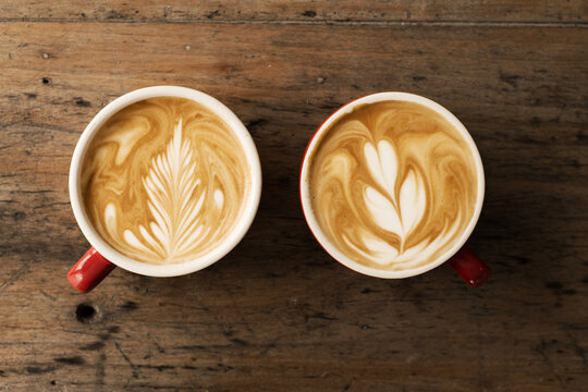 flat white coffees on a timber table, with beautiful latte art
