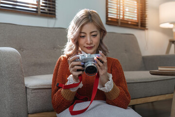 Portrait of pretty young woman looking at pictures from the camera