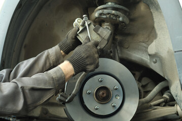 Car maintenance and repair in a car service center. Replacement of brake pads and discs. An auto...